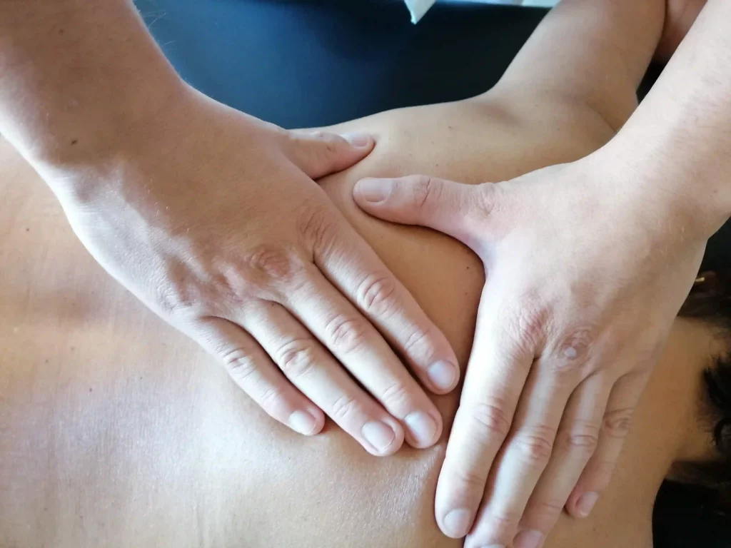 les mains d'un ostéopathe à perpignan traitant le mal de dos d'une patiente